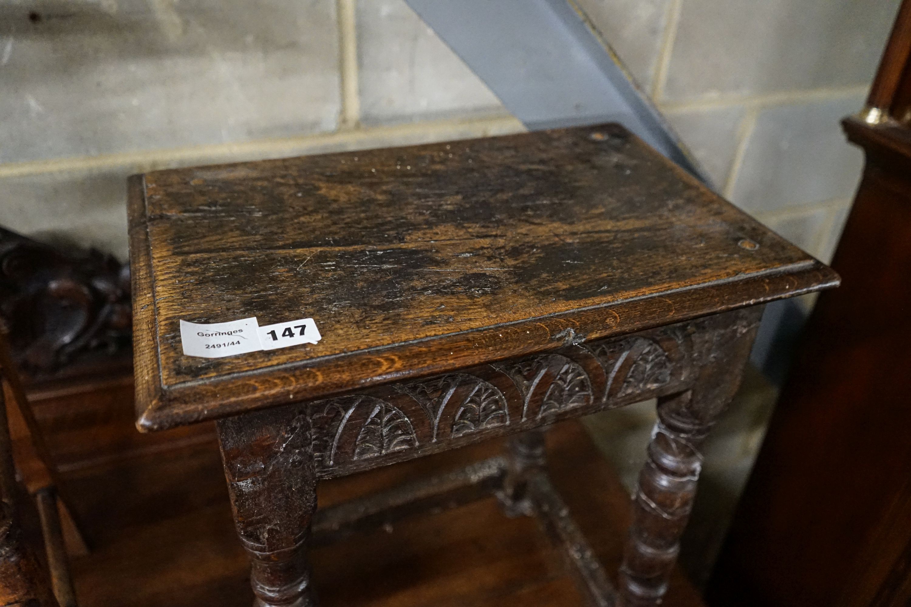 A 17th century style oak joint stool, with foliate carved frieze and turned legs, width 44cm, depth 28cm, height 56cm